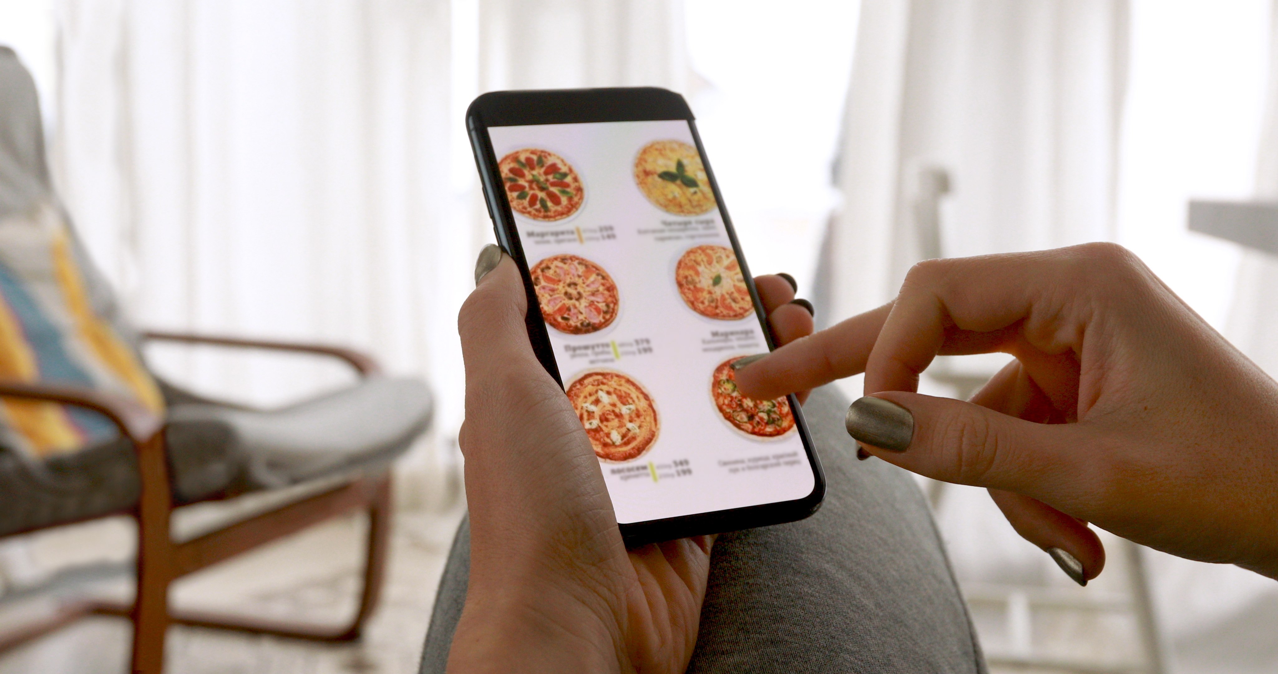 Persona consultando una carta de pizzas desde el móvil
